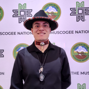 Travis Paakonen in traditional attire smiling